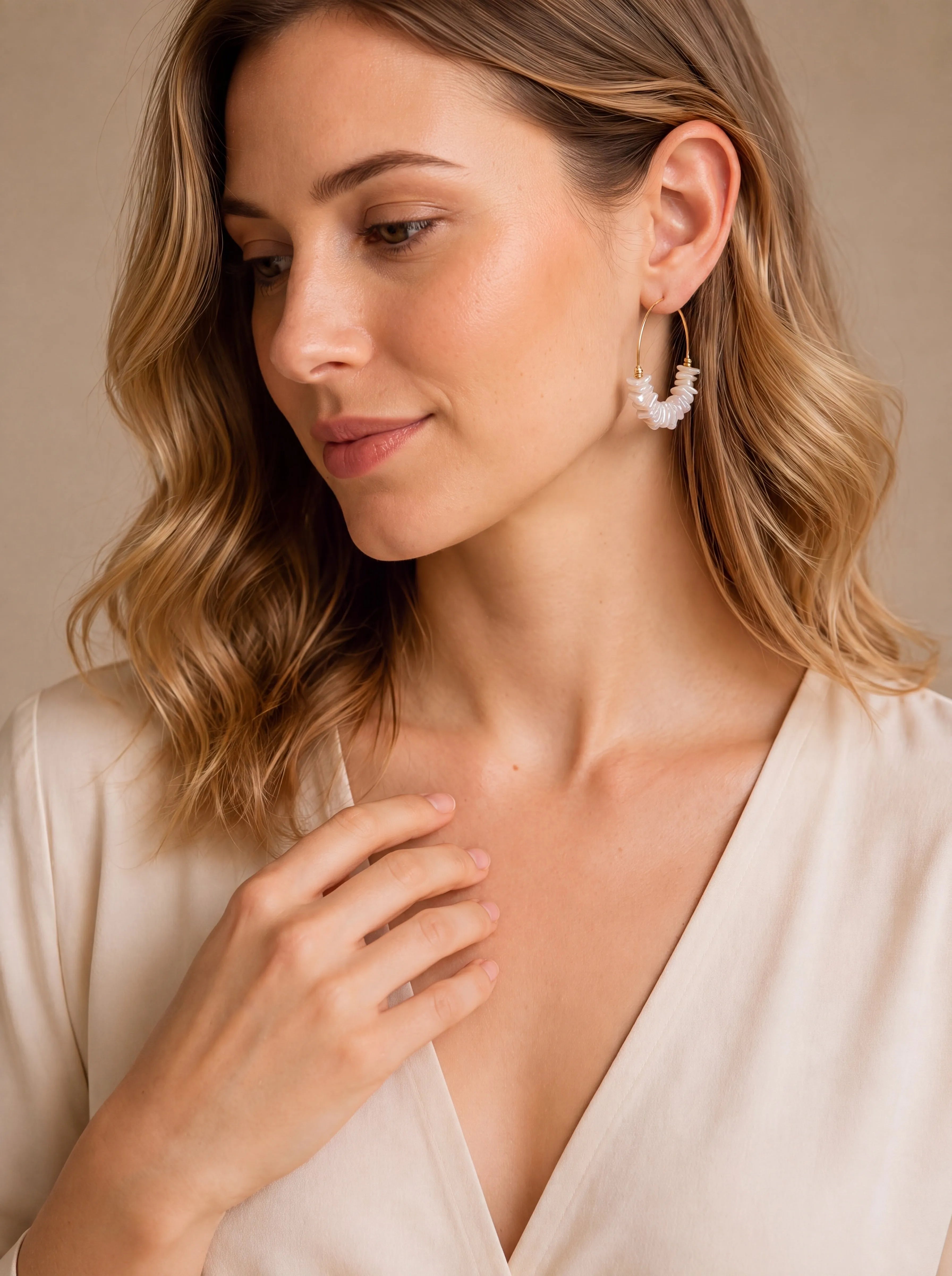 Créoles dorées de 40 mm ornées de perles de nacre naturelle irrégulières portées par une femme élégante.