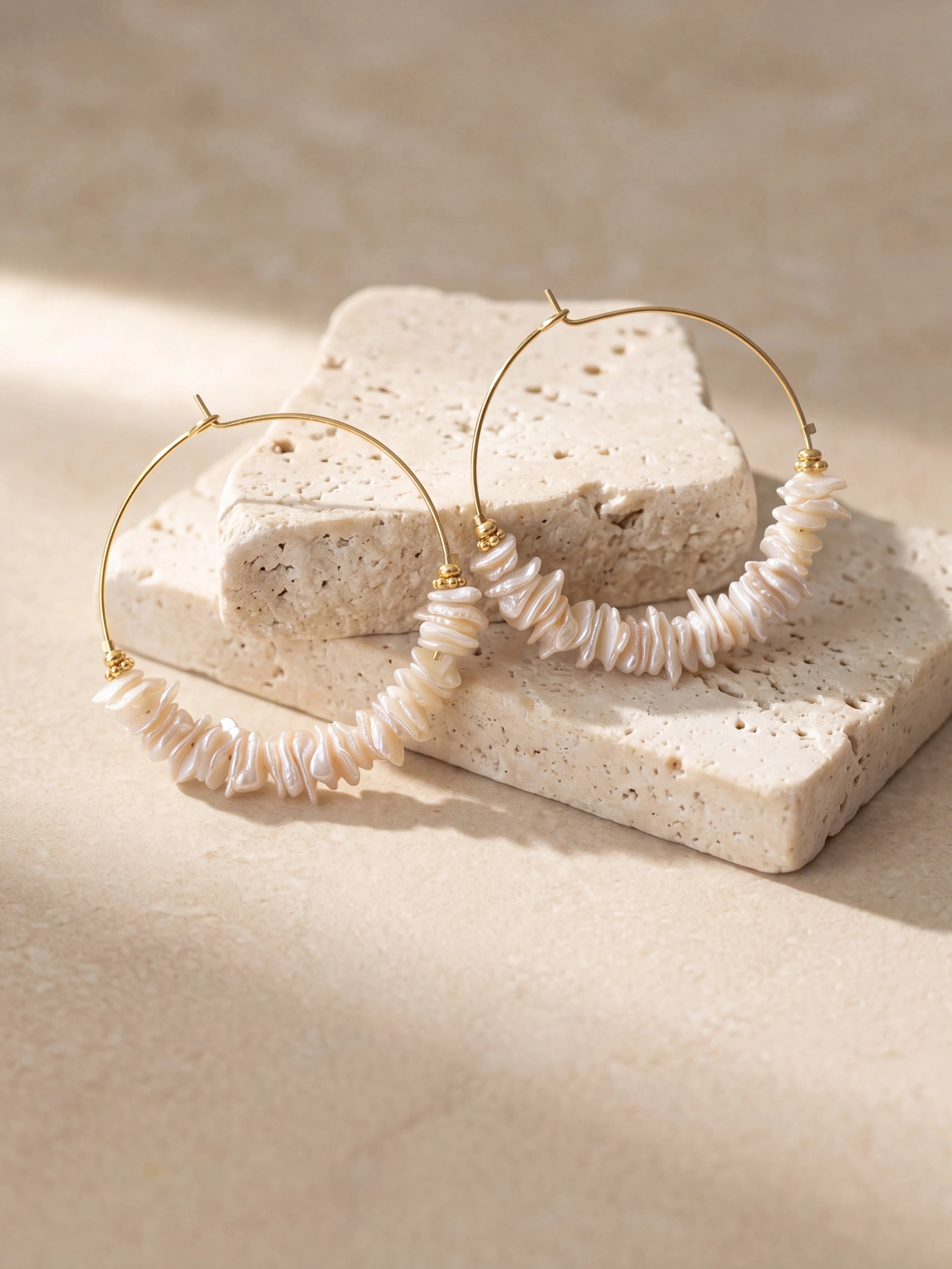 Créoles dorées de 40 mm ornées de perles de nacre irrégulières en forme de chips et de petites perles dorées.