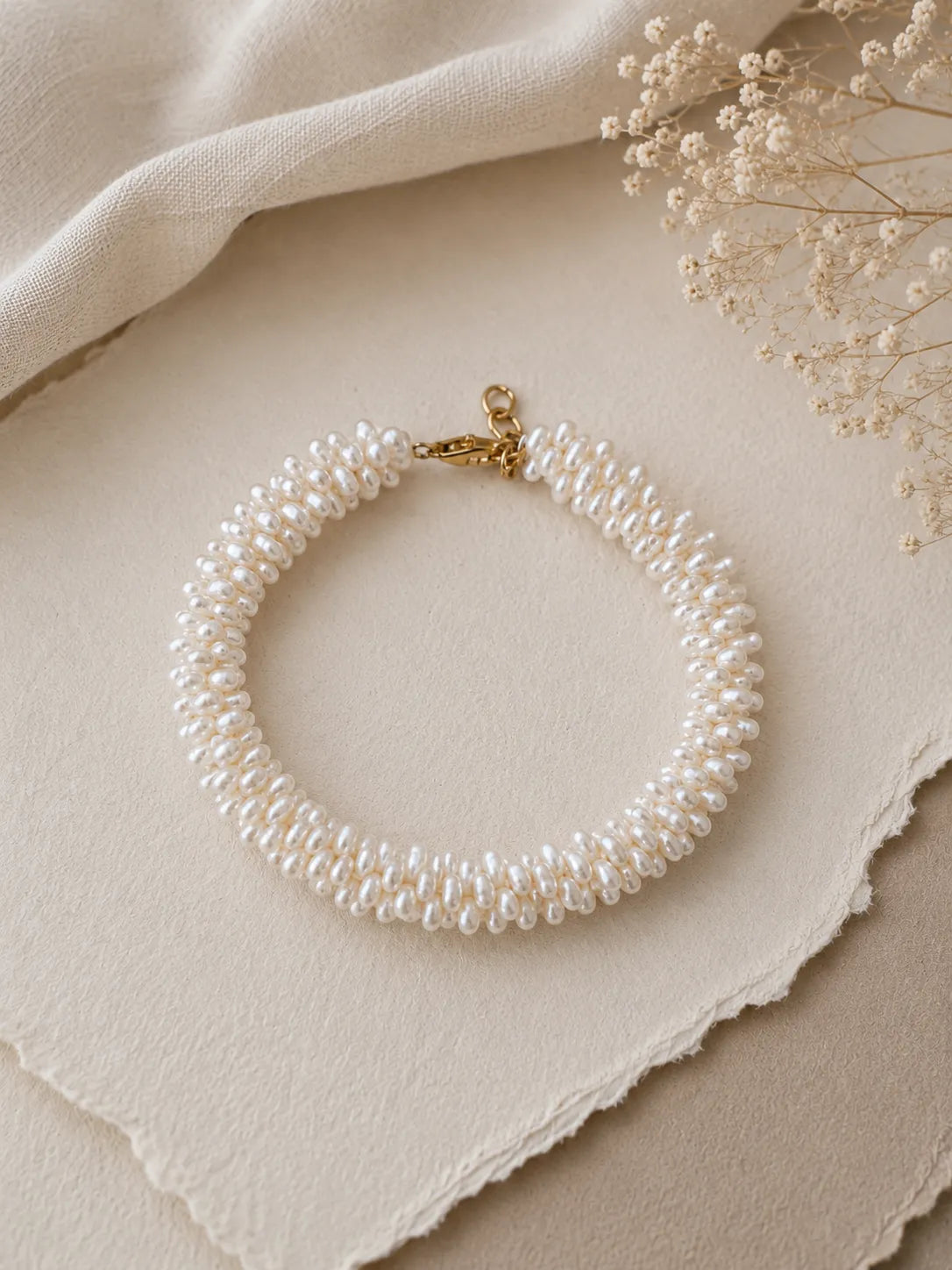 Bracelet NACELIE en perles d'eau douce tissées à la main avec fermoir et finitions en laiton doré à l'or 24 carats.