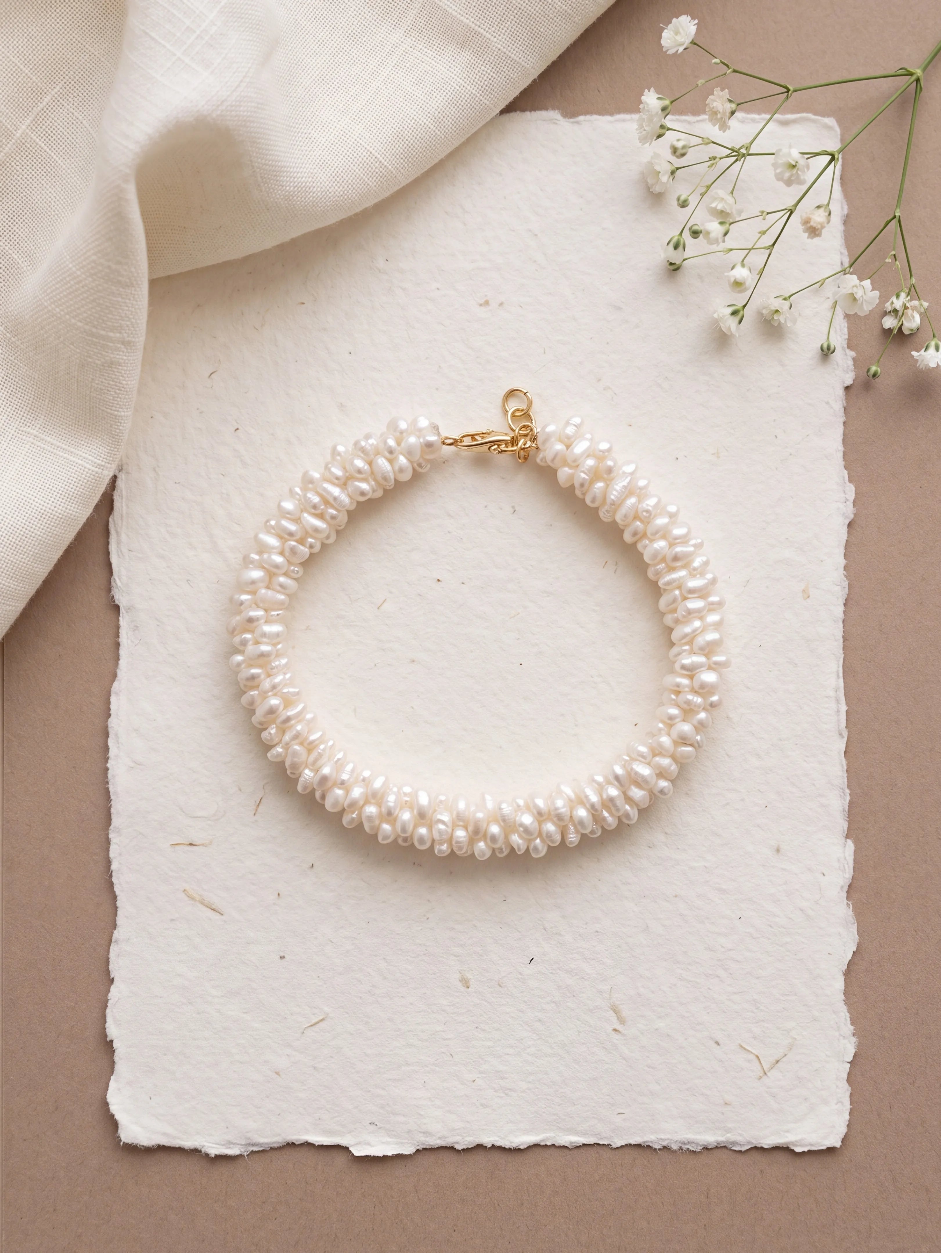 Bracelet NACELIE en perles d'eau douce tissées à la main avec fermoir et finitions en laiton doré à l'or 24 carats.